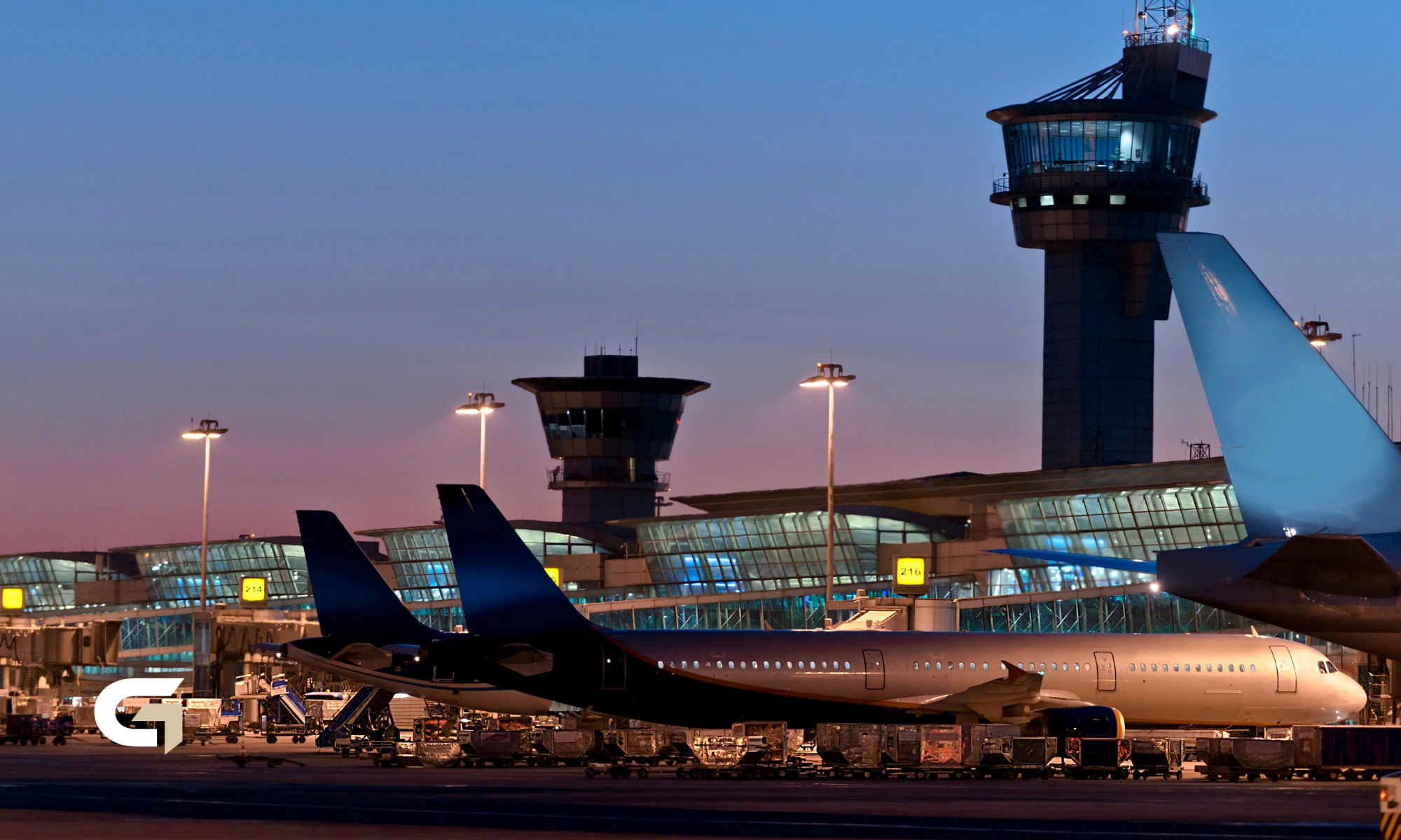 Flughafen Brüssel-Charleroi bei Abenddämmerung, Tower und Terminal mit Flugzeugen am Gate