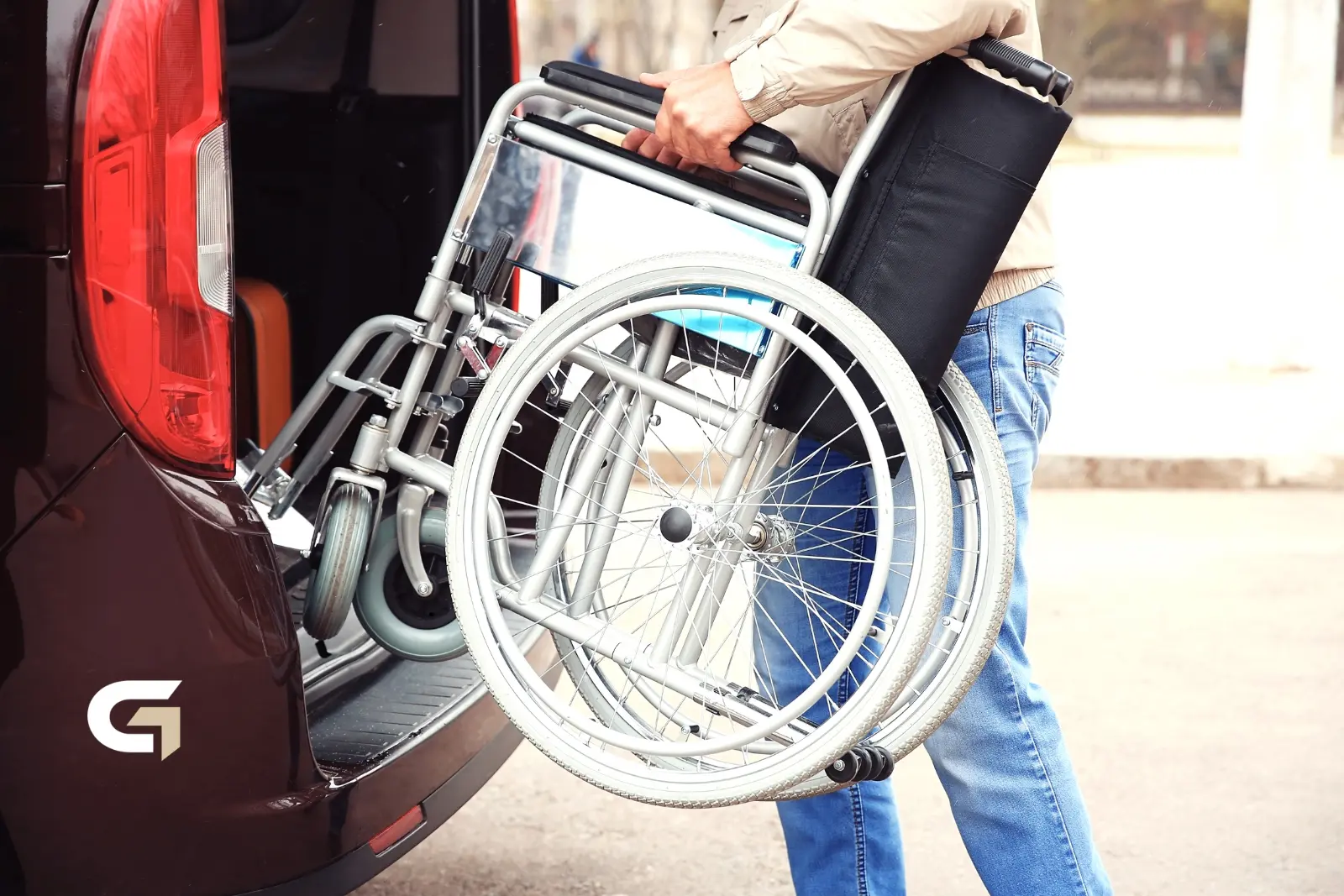Fahrten mit Rollstuhl in Würselen: zusammengeklappter Rollstuhl wird in den Kofferraum gehoben